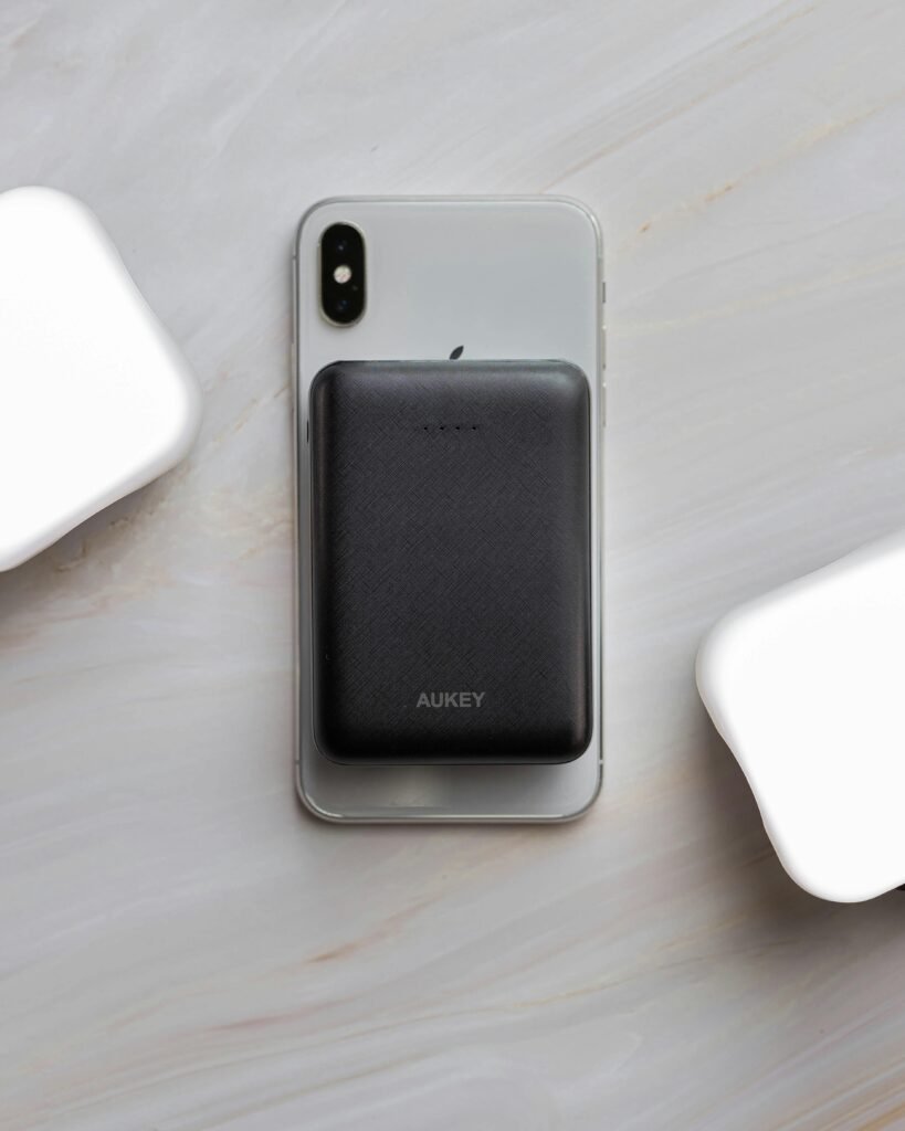 Minimalist image of a smartphone paired with a compact power bank on a marble surface, featuring sleek and modern design.